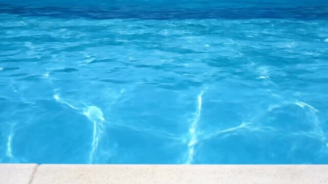 Rippling Blue Pool Water - A close-up view of the surface of a swimming pool, featuring clear blue water with soft rippling waves.