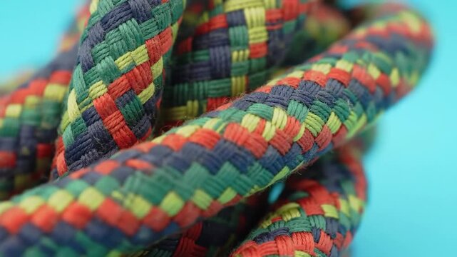 Close-up of a colorful braided rope, showcasing its intricate pattern and texture against blue.