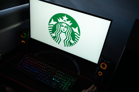 Punta Arenas, Chile &ndash; January 20, 2026: A desktop monitor featuring the stylized Starbucks Siren logo alongside glowing computer peripherals and RGB lighting
