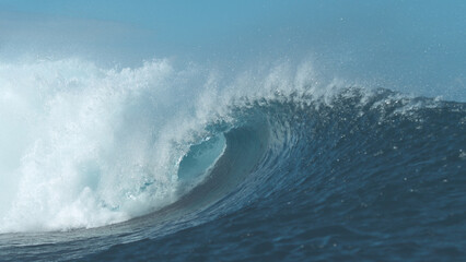 CLOSE UP: Stunning barrel wave shines brightly in the pretty summer sunlight.