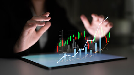 A professional businessperson engages with digital financial data on a tablet screen, showcasing modern technology and advanced analysis methods in a corporate setting. Scalp