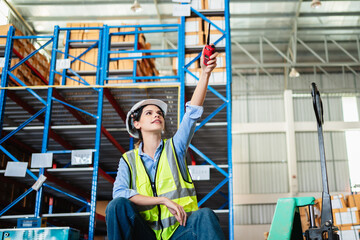 Warehouse worker in safety vest and hard hat in a large storage facility. Logistics, inventory...