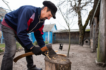 A man chops wood with an axe. Worker with axe. Rural housework