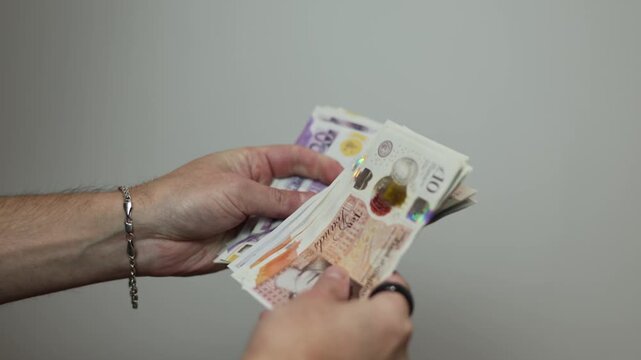 Close Up of Hands Counting British Pound Banknotes, Financial Concept and Cash Payment