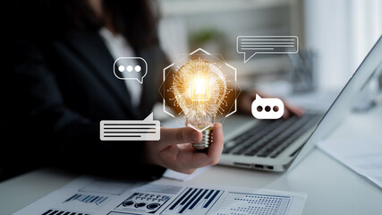 A businesswoman holds a light bulb symbolizing innovative ideas while using a laptop, surrounded by digital communication icons in a modern office space. Gantry