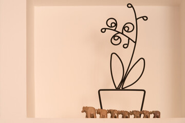 Home decor. A wire table panel and seven elephant figurines in a niche.