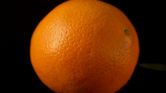 Rotating whole orange in extreme close-up highlighting peel texture and natural color. Ideal for freshness, agriculture, and food detail visuals.