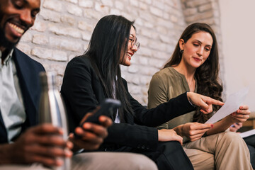 Professional job applicants waiting together in an office interview room, expressing anticipation, stress, and hope for career opportunity.