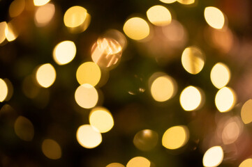 Gold bokeh Christmas lights with amber abstract background