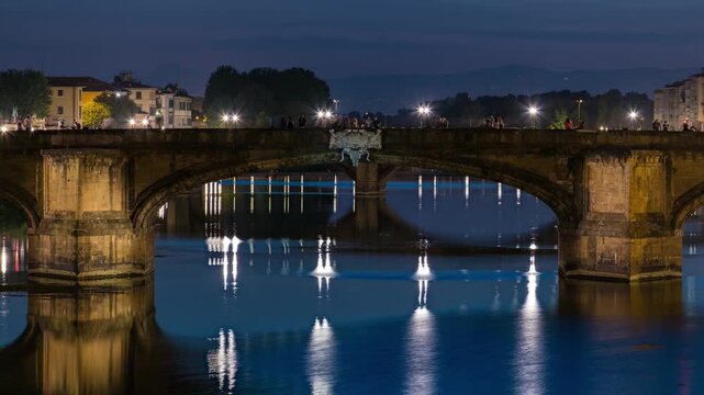 Twilight scene of Ponte Santa Trinita (Holy Trinity Bridge) day to night transition timelapse over River Arno with reflections on water after sunset. Close up view. Florence, Tuscany, Italy