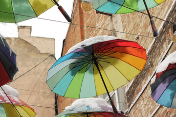 Vibrant Rainbow Umbrellas Covered in Snow Hanging Outdoors