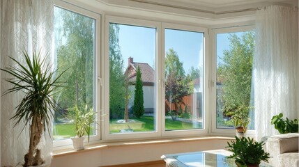 Bright interior space features a wide bay window overlooking a lush summer garden