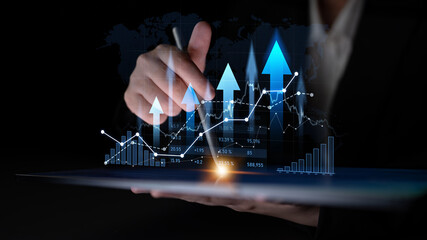 A businessman holds a tablet displaying digital graphs and arrows, illustrating upward financial growth and success trends in a modern business environment. Scalp