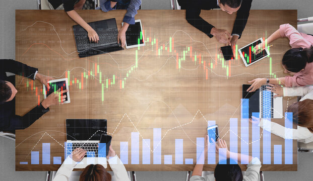 A diverse team engages in a collaborative meeting to analyze financial data using tablets and laptops, surrounded by graphs and charts showcasing market trends and insights. Scalp - Powered by Adobe