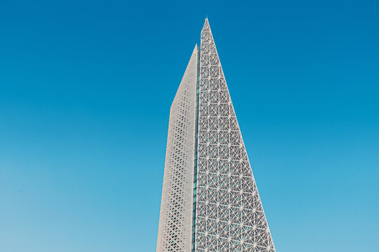 30 November 2025, Doha, Qatar: Modern architecture of Burj Al Mana skyscraper in West Bay district against blue sky