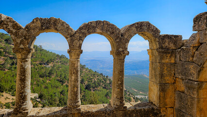 Series of ancient stone arches framing a distant mountain landscape symbolizing timeless...
