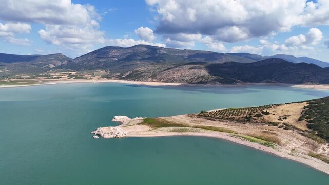 Aerial drone cinematic video of artificial lake of Yliki in Boeotia prefecture with calm waters and beautiful clouds, an important source of drinking water for the Athens, Greece