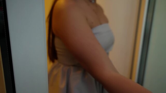 Close-up view of sliding glass door panels with aluminum frames and a yellow safety dot on frosted glazing, showcasing minimalist interior architecture with vertical lines, bokeh.