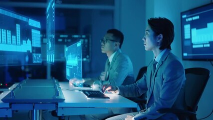 Corporate team collaborating on digital project using interactive holographic screens. Professional men analyzing financial statistics in dark high-tech workspace. - Powered by Adobe