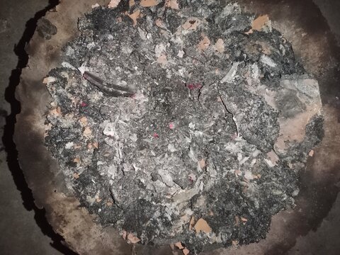 Texture of powdery gray ash after a bonfire or wood fire,Close-up of gray ash wood marked &ldquo;akk,&rdquo; with burning white bark and charcoal wood in the background