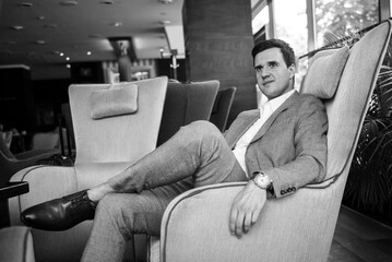 portrait of a young groom in a blue jacket and white shirt in a bright studio