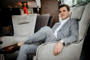 portrait of a young groom in a blue jacket and white shirt in a bright studio