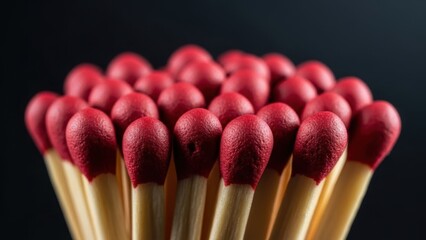 Close-up of a bundle of red-tipped matches against a dark background.