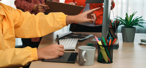 Engaging office scene featuring a diverse team in a creative meeting, using digital and traditional tools for brainstorming and idea sharing. SACTR
