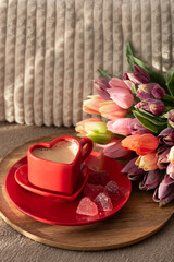 Heart Shaped Coffee Cup with Colorful Tulips and Candies. Cozy Romantic Flatlay on Sofa for...