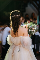 bride in a white dress throws a wedding bouquet