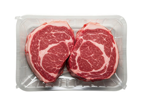 Fresh uncooked ribeye beef steaks vacuum sealed in clear plastic tray ready for grilling