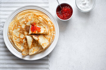Homemade thin crepes with red caviar