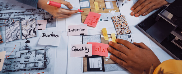 A dynamic workspace image showcasing hands engaged in a creative collaborative design process with colorful notes and architectural sketches for improved project outcomes. SACTR © InfiniteFlow