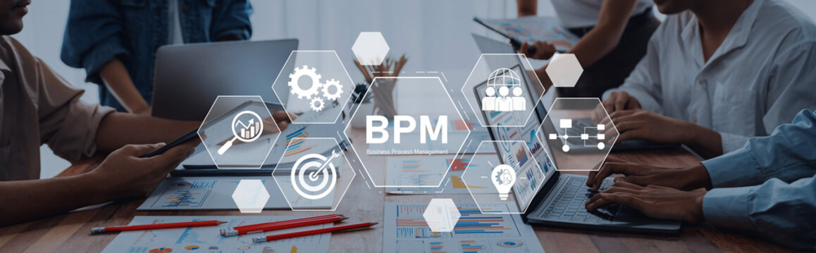 A group of professionals collaborates in an office setting, utilizing technology tools for business process management, workflow improvement, and efficiency analysis. Trope