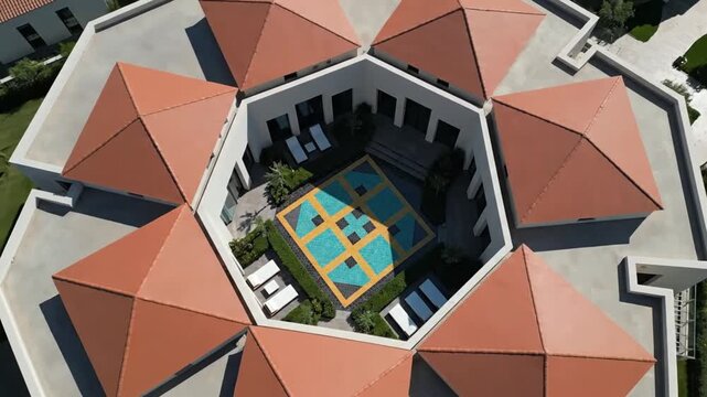 Aerial view of modern octagonal building with pool