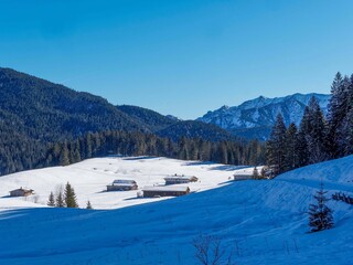 Snowy Bavarian Alps. Around Spitzinsee. Chalets on the slopes of Stolzenberg, Rorkopf and Rosskopf. Gleiselstein and Pfannkopf. On left slope of Schwarzenkopf and Hinteres Sonnwendjoch on horizon
