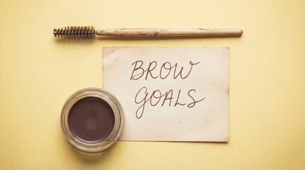Makeup tools with brow tint and "Brow Goals" message on yellow background  
