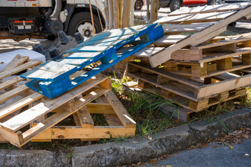 Pile of used wooden pallets stacked outside