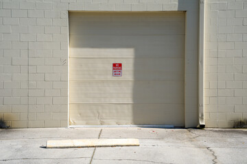 Exterior Rollup Door on an Industrial Building With No Parking Sign