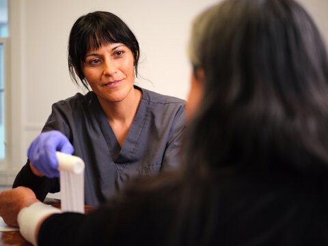 Elderly woman gets at-home wound care from Native American nurse