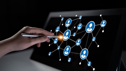 A hand uses a stylus to interact with a touchscreen showcasing a complex network of user icons, symbolizing communication and connectivity in the digital landscape. Tessel