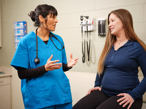 Native American nurse consults with young female patient in a clinic setting