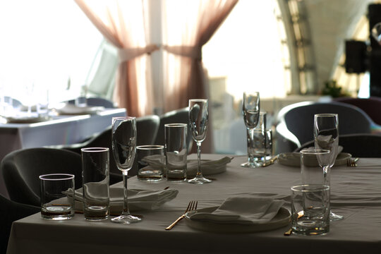 Beautiful table setting with dishes,in a restaurant,light-shadow pattern and style