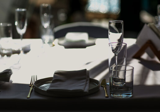 Beautiful table setting with dishes,in a restaurant,light-shadow pattern and style