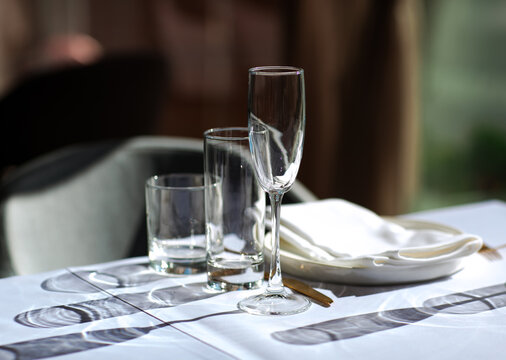 Beautiful table setting with dishes,in a restaurant,light-shadow pattern and style