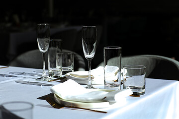Fototapeta premium Beautiful table setting with dishes,in a restaurant,light-shadow pattern and style