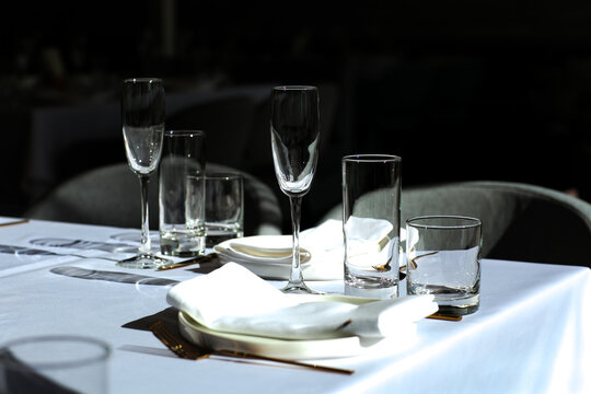 Beautiful table setting with dishes,in a restaurant,light-shadow pattern and style