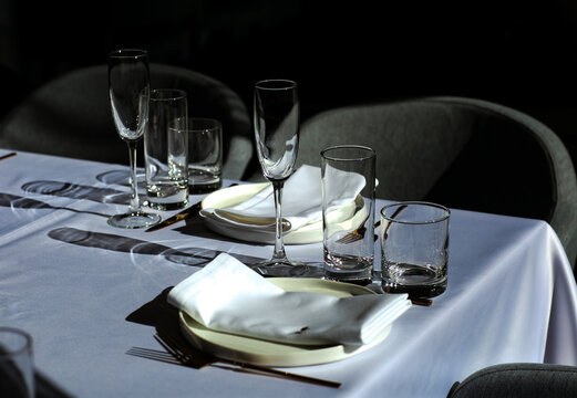 Beautiful table setting with dishes,in a restaurant,light-shadow pattern and style