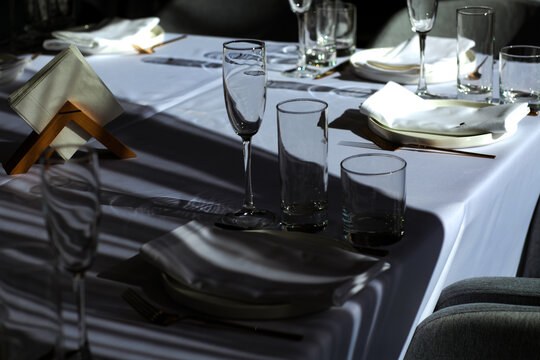 Beautiful table setting with dishes,in a restaurant,light-shadow pattern and style
