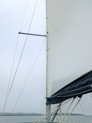 Obraz premium Sailboat mast and sails against cloudy sky